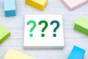付箋の上に浮かぶ3つのクエスチョンマーク