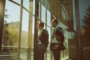 外を眺める2人のビジネスパーソン