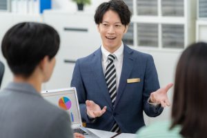 若い夫婦と商談をする営業マン