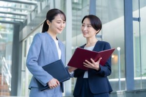 ファイルを手に話をするビジネスウーマン