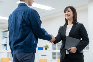 オフィスで笑顔で握手するビジネスウーマン