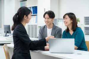 若い夫婦に説明をするビジネスウーマン