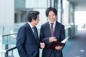 オフィスで上司と資料の確認をするビジネスマン