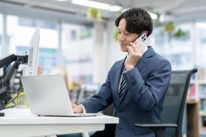 オフィスで電話をかける男性